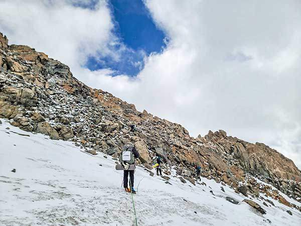 전진베이스캠프에서 베이스캠프로 내려가기 위해 안자일렌을 하고 한 명씩 암벽구간을 넘어가고 있다.
