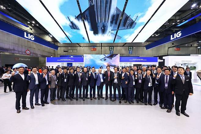 신익현 LIG넥스원 대표이사(왼쪽 열번째)가 지난 23일 ADEX 2025의 LIG넥스원 부스에서 A1 Society 대표단과 기념촬영을 하고 있다. LIG넥스원 제공