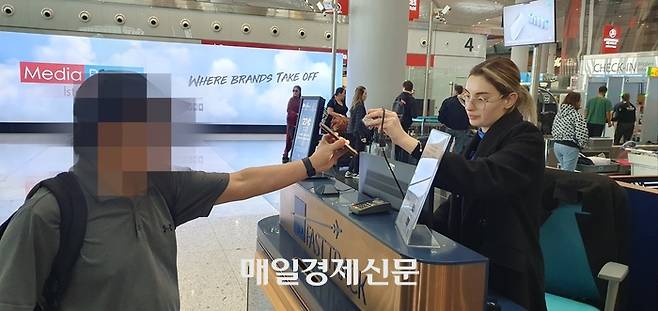 지난 17일 오후(현지시각) 튀르키예 이스탄불국제공항에서 한 여객이 유료 패스트 트랙을 이용하기 위해 산 이용권의 QR 코드를 관련 직원에게 제시하고 있다. 지홍구기자