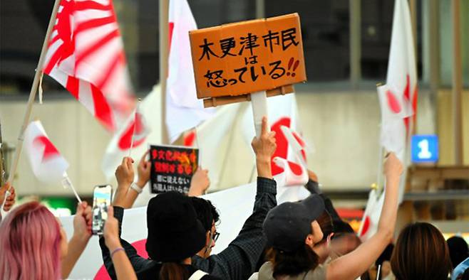 지난 7월 일본 도쿄에서 시민들이 참정당의 인종 차별 및 민족주의 정책에 반대하는 피켓 등을 들어 보이고 있다. 도쿄=AP연합뉴스