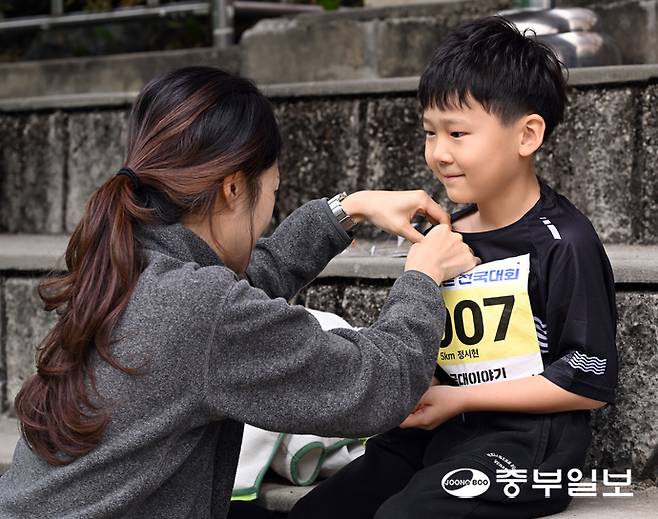마라톤에 참가한 시민이 아들에게 배번호를 달아주고 있다. 임채운기자