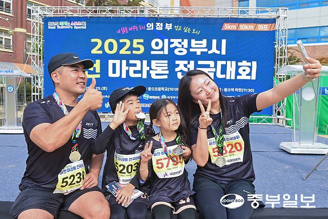 마라톤을 완주한 가족들이 메달을 들고 셀카를 찍고 있다. 임채운기자