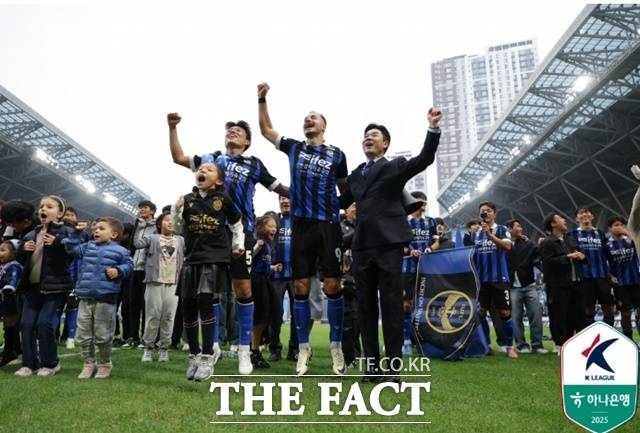 인천 유나이티드를 강등 1년 만에 1부 승격으로 이끈 윤정환 감독(오른쪽)과 선수들이 감격을 나누고 있다./인천=K리그