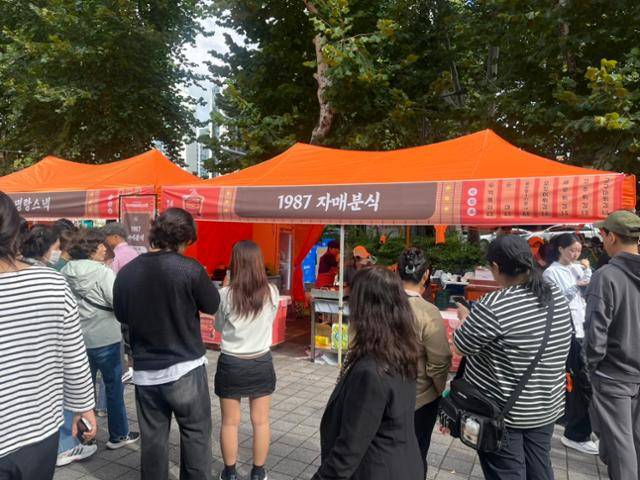 24일 대구 북구 고성동 대구iM뱅크파크 앞 주차장에서 열린 '제5회 떡볶이 페스티벌'을 찾은 시민들이 떡볶이를 맛보기 위해 줄을 서고 있다. 대구=김재현 기자