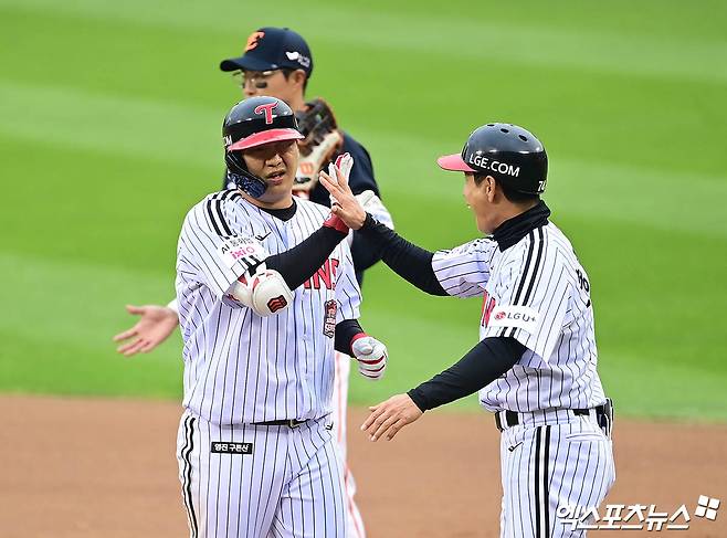 26일 오후 서울 송파구 잠실야구장에서 열린 '2025 신한 SOL Bank KBO 한국시리즈' 한화 이글스와 LG 트윈스의 1차전 경기, 6회말 2사 1,2루 LG 문보경이 적시타를 때려낸 뒤 1루에서 송지만 주루코치와 하이파이브를 나누고 있다. 잠실, 박지영 기자