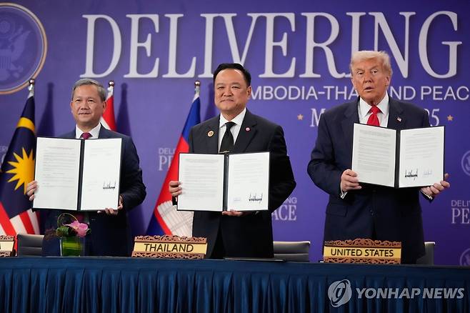 트럼프, 태국-캄보디아 휴전협정식 주재 (쿠알라룸푸르 AP=연합뉴스) 26일(현지시간) 말레이시아 쿠알라룸푸르에서 도널드 트럼프 미국 대통령과 아누틴 찬위라꾼 태국 총리(가운데), 훈 마네트 캄보디아 총리(왼쪽)이 태국-캄보디아 휴전협정문을 들어 보이고 있다.