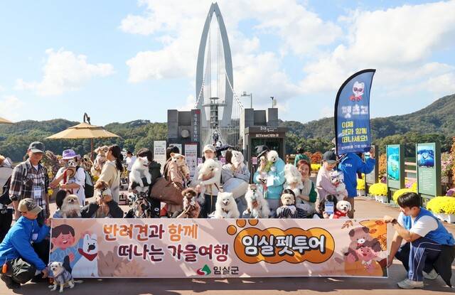 전국 각지에서 반려견과 함께 떠나는 가을여행에 참가한 반려인들이 옥정호 출렁다리에서 기념촬영을 하고 있다 임실군