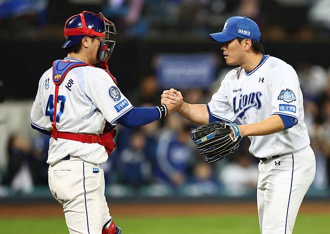 지난 22일 대구삼성라이온즈파크에서 열린 2025 KBO 포스트시즌 플레이오프 한화 이글스 대 삼성 라이온즈 4차전. 경기가 끝난 후 삼성 투수 김재윤과 포수 강민호가 악수하고 있다. 연합뉴스