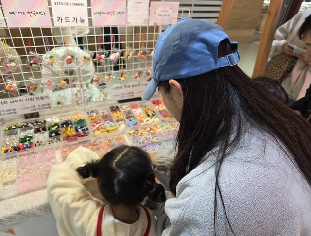 서울 강서구 마곡동 원그로브몰에서 26일 아이와 함께 방문한 고객이 키링 만들기 체험을 하고 있다. [사진= 김수연기자]