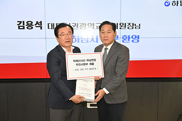 이현재 시장이 지난 24일 하남시청을 방문한 김용석 대도시권광역교통위원회 위원장에게 위례·감일 주민 1만8637명의 서명부를 전달하고 있다. [사진=하남시]