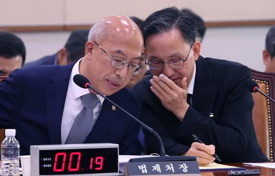 조원철 법제처장(왼쪽)이 지난 24일 국회에서 열린 법제사법위원회의 법제처에 대한 국정감사 도중에 김창범 차장과 대화하고 있다. 임현동 기자