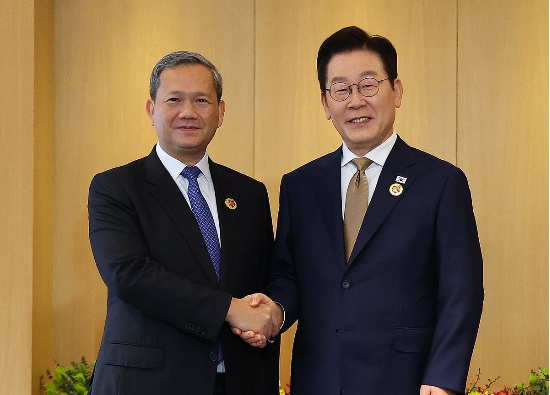 이재명 대통령(오른쪽)과 훈 마네트 캄보디아 총리가 27일 말레이시아 쿠알라룸푸르 한 호텔에서 정상회담에 앞서 악수하고 있다.