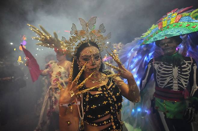 [멕시코시티=AP/뉴시스] 26일(현지 시간) 멕시코 수도 멕시코시티에서 해골 분장을 사람들이 연례 망자의 날 ‘카트리나 퍼레이드’에 참가하고 있다. '죽은 자들의 날'은 매년 10월 31일부터 11월 2일까지 죽은 이들을 기리는 멕시코 명절이다. 멕시코인들은 세상을 떠난 이들이 1년에 한 번 가족과 친구를 만나러 세상에 내려온다고 믿어 10월 말일에 제단을 마련한 뒤 11월 1일에는 죽은 아이들을, 11월 2일에는 죽은 어른들을 위해 기도를 올린다. 2025.10.27.