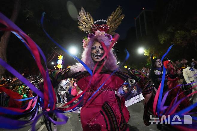 [멕시코시티=AP/뉴시스] 26일(현지 시간) 멕시코 수도 멕시코시티에서 해골 분장을 사람들이 연례 망자의 날 ‘카트리나 퍼레이드’에 참가하고 있다. '죽은 자들의 날'은 매년 10월 31일부터 11월 2일까지 죽은 이들을 기리는 멕시코 명절이다. 멕시코인들은 세상을 떠난 이들이 1년에 한 번 가족과 친구를 만나러 세상에 내려온다고 믿어 10월 말일에 제단을 마련한 뒤 11월 1일에는 죽은 아이들을, 11월 2일에는 죽은 어른들을 위해 기도를 올린다. 2025.10.27.