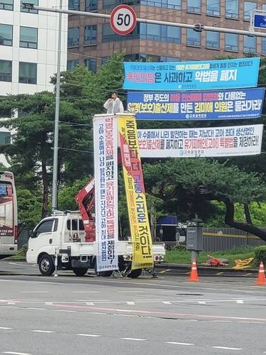 "익명출산제 폐기하고 고아특별법 제정하라" 사다리차를 이용해 시위를 벌이고 있는조윤환 고아권익연대 대표
[고아권익연대 제공]