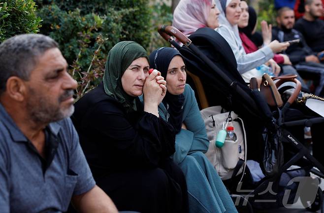 13일(현지시간) 하마스와 이스라엘 간 인질-수감자 교환 및 휴전 협정의 일환으로 팔레스타인 수감자들이 이스라엘 감옥에서 풀려나자 이스라엘이 점령한 요르단강 서안지구 라말라에서 가족들이 친족을 기다리고 있다. 2025.10.13. ⓒ 로이터=뉴스1 ⓒ News1 이정환 기자
