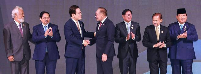 이재명 대통령이 27일 말레이시아 쿠알라룸푸르 컨벤션센터에서 열린 한-아세안 정상회의에서 올해 의장국인 말레이시아의 안와르 이브라힘 총리와 악수하고 있다. 왼쪽부터 사나나 구스마오 동티모르 총리, 팜민찐 베트남 총리, 이 대통령, 안와르 총리, 페르디난드 마르코스 필리핀 대통령, 하사날 볼키아 브루나이 국왕, 프라보워 수비안토 인도네시아 대통령. 쿠알라룸푸르=뉴시스
