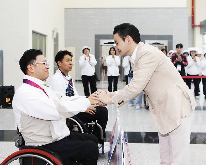 배동현 이사장이 시상식에서 금메달을 획득한 김정남 선수와 악수를 나누고 있다.