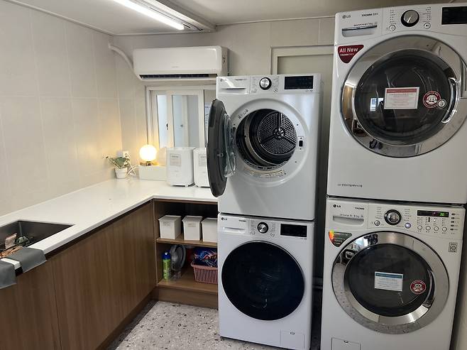 Laundry machines and dryers are at the shared laundry zone in the gosiwon (small, affordable single-room housing) building where Lydia Rouka lives. [LYDIA ROUKA]