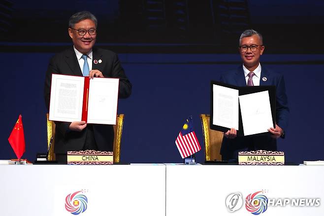 중국·아세안, FTA '버전 3.0' 확대개정안 체결 (쿠알라룸푸르 EPA=연합뉴스) 28일(현지시간) 말레이시아 쿠알라룸푸르에서 중국의 왕원타오 상무부장(장관·왼쪽)과 틍쿠 자프룰 아지즈 말레이시아 투자통상산업부 장관이 아세안-중국 자유무역협정(FTA) '버전 3.0' 확대 개정안에 서명한 모습.