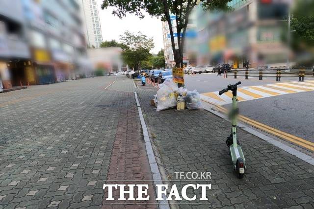 지난 24일 인천 연수구 송도동 한 인도에 전동 킥보드가 주차돼 있다. 6일 전 이곳에서 중학생 두 명이 탄 전동 킥보드가 30대 여성을 치는 사고가 발생했다. /이상빈 기자