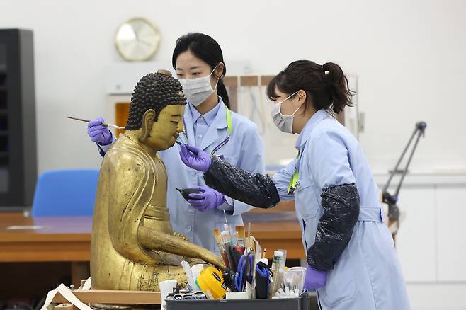 서울 용산구 국립중앙박물관 보존과학센터 목재실에서 관계자들이 목재불상 건식세척작업을 하고 있다. /연합뉴스