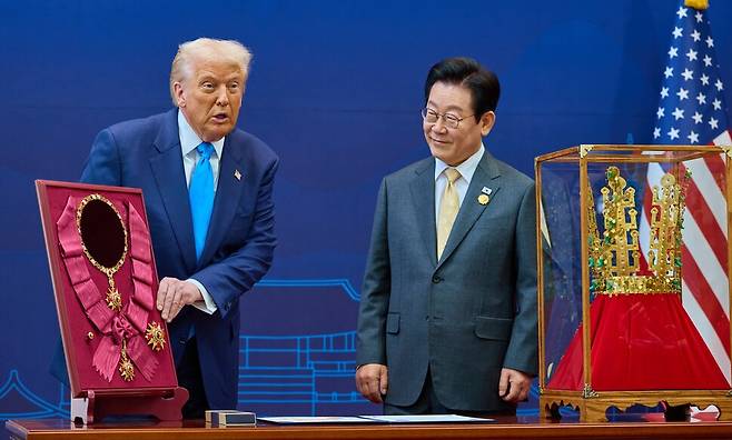 이재명 대통령이 29일 경북 경주박물관에서 열린 한미 정상회담에서 도널드 트럼프 미국 대통령에게 무궁화 대훈장을 수여하고 천마총 금관 모형을 선물하고 있다. 대통령실 제공