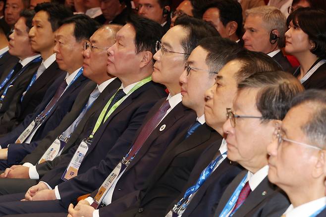From left: Shinsegae Group Chair Chung Yong-jin, HD Hyundai Chairman Chung Ki-sun, Lotte Group Chairman Shin Dong-bin, Hyundai Motor Group Executive Chair Chung Euisun, SK Group Chairman Chey Tae-won, Samsung Electronics Chairman Lee Jae-yong, LG Group Chairman Koo Kwang-mo, Posco Group Chairman Chang In-hwa, GS Group Chairman Huh Tae-soo and Hanwha Group Vice Chairman Yeo Seung-joo listen to President Lee Jae Myung's opening speech for the APEC CEO Summit 2025 held at the Gyeongju Arts Center on Wednesday. (Yonhap)
