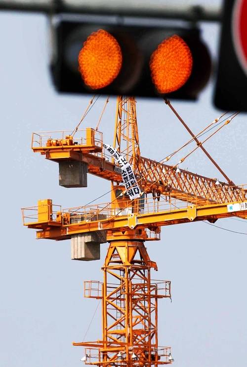 한 수도권 아파트 공사현장에 타워크레인이 멈춰 서 있다. 올스톱된 공사장을 상징하듯 빨간 신호등이 켜져 있다. [김호영 기자]