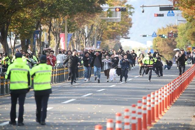 29일 오후 한미 정상회담이 열린 국립경주박물관 인근에서 도널드 트럼프 미국 대통령을 반대하는 기습 시위대가 경찰저지선을 뚫고 정상회담장으로 질주하고 있다. 연합뉴스