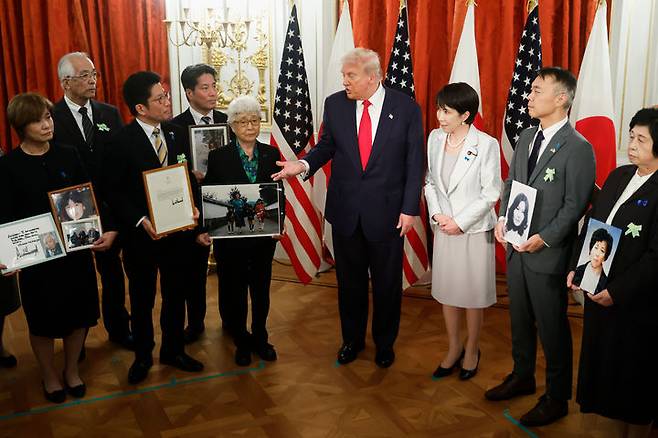 [도쿄=AP/뉴시스]도널드 트럼프(가운데) 미국 대통령과 다카이치 사나에(트럼프 대통령 오른쪽) 일본 총리가 지난 28일 도쿄 아카사카 영빈관에서 북한 납치 피해자 가족들과 면담하고 있다. 가족들은 납치된 피해자의 사진을 들고 있다. 2025.10.29.