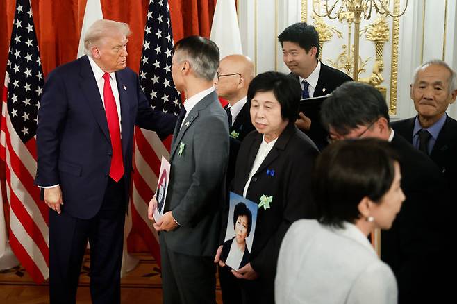 [도쿄=AP/뉴시스]도널드 트럼프(왼쪽) 미국 대통령과 다카이치 사나에(가장 오른쪽) 일본 총리가 지난 28일 도쿄 아카사카 영빈관에서 북한 납치 피해자 가족들과 면담하고 있다. 가족들은 납치된 피해자의 사진을 들고 있다. 2025.10.29.