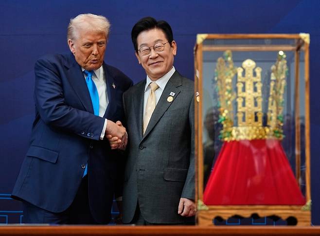 도널드 트럼프 미국 대통령이 29일 경주 국립박물관에서 열린 훈장 수여식에서 이재명 한국 대통령과 악수하고 있다. 트럼프 대통령은 미국 대통령 최초로 무궁화대훈장을 받았다. AP연합뉴스