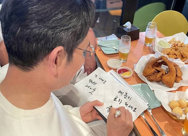 어린이에게 사인해주는 이재용 회장 - 이재용 삼성전자 회장이 30일 서울 삼성동 한 치킨집에서 진행된 젠슨 황 엔비디아 최고경영자, 정의선 현대차그룹 회장과의 치맥 회동에서 한 어린이에게 사인을 해주고 있다. 2025.10.30 연합뉴스