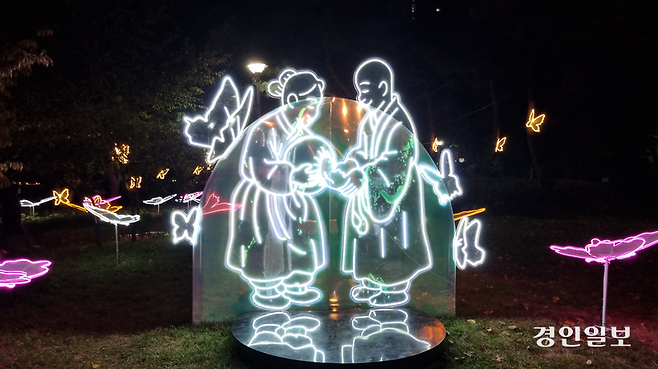 구리 빛 축제의 첫번째 조형물은 장자못 설화 속 탁발승에게 쌀을 주는 며느리 조형물이다. 시아버지의 잘못을 사과하고 시주하는 며느리 주변에 나비가 팔락인다. 2025.10.27 구리/권순정기자 sj@kyeongin.com