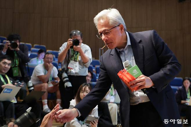 젠슨 황 엔비디아 최고경영자(CEO)가 31일 경북 경주시 경주예술의전당 원화홀에서 열린 엔비디아 기자회견에서 취재진에게 과자를 건네고 있다. 박형기 기자 oneshot@donga.com