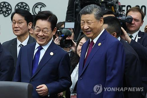 이재명 대통령이 31일 경주화백컨벤션센터(HICO)에서 열린 2025 아시아태평양경제협력체(APEC) 정상회의 제1세션에서 시진핑 중국 국가주석과 대화하고 있다.    [연합뉴스]