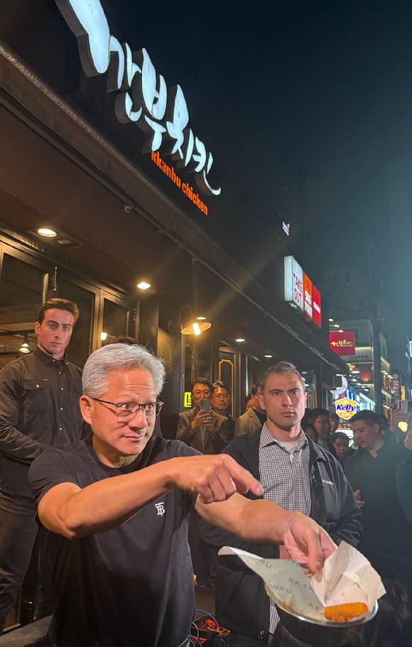 젠슨 황 엔비디아 CEO가 30일 서울 강남구 깐부치킨에서 기자들에게 감자튀김을 나눠주고 있다. [사진=권서아 기자]