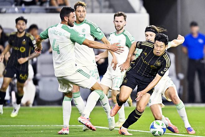 LAFC 손흥민(오른쪽)이 오스틴 선수들 사이로 드리블 돌파를 하고 있다. [로이터=연합뉴스]