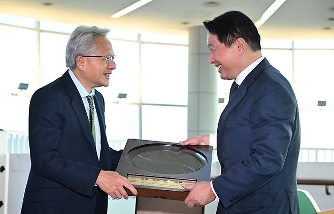 젠슨 황 엔비디아 CEO가 31일 경북 경주시 경주예술의전당에서 열린 아시아태평양경제협력체(APEC) CEO 서밋에 참석해 최태원 SK그룹 회장 겸 대한상의 회장으로 부터 SK하이닉스의 HBM4 반도체 웨이퍼를 선물로 받고 있다. 25.10.31 [경주/한주형기자]
