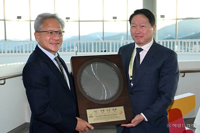 젠슨 황(왼쪽) 엔비디아 최고경영자(CEO)가 31일 경북 경주시 경주예술의전당에서 열린 APEC CEO 서밋 2025에 참석해 최태원 SK그룹 회장 겸 대한상공회의소 회장으로부터 SK하이닉스의 HBM4 반도체 웨이퍼를 선물로 받고 있다. 경주=임세준 기자