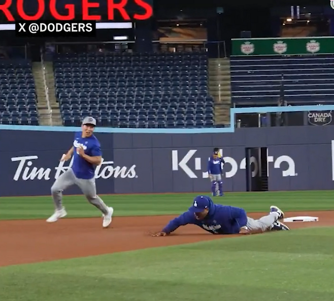 ▲ 왼쪽부터 LA 다저스 김혜성, 데이브 로버츠 감독. 31일 월드시리즈 6차전을 앞두고 훈련하다 달리기 대결을 펼쳤다. 로버츠 감독은 질주하다 넘어졌다. ⓒMLB.com 공식 홈페이지