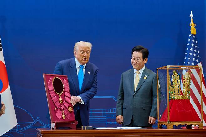 도널드 트럼프(왼쪽) 미국 대통령이 29일 경주 박물관에서 이재명 대통령이 지켜보는 가운데 우리나라 정부가 선물한 무궁화 대훈장과 신라 천마총 금관 모형을 살펴보고 있다. /뉴스1