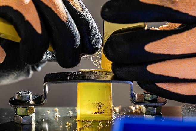 한국 금거래소 직원이 골드바 무게(10g)를 맞추기 위해 도구로 금을 깎아내는 작업을 하고 있다. 전민규 기자