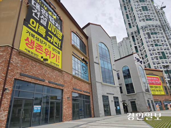 지난달 31일 시흥시 거북섬 빈 상가 건물 외벽에 ‘거북섬 대관람차 건설을 이행하라’는 내용의 대형 현수막이 걸려있다. 2025.10.31 /김태강기자 think@kyeongin.com