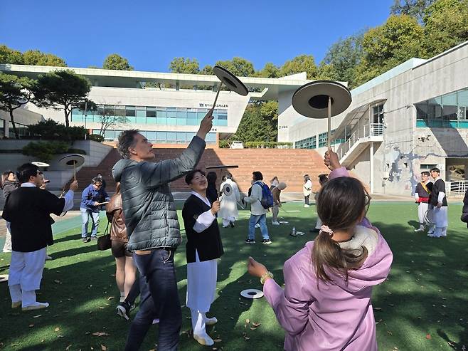 1일 경기국악원에서 열린 국악체험프로그램 '한국을 느끼다: 국악체험'에 참여한 외국인 관광객들이 '그룹사운드 소쩍새'와 함께 버나놀이를 체험하고 있다.