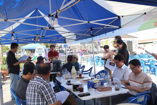 동성동 치맥축제 현장탐방 중 권성일 팀장은 주민과 관계자들과 함께 소통하며 인구 정책과 마을 활성화 방안을 격의없이 논의하고 있다.