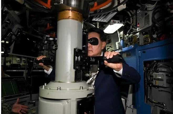 윤석열 지난 대통령이 지난 2023년 7월19일 부산 남구 해군작전사령부 부산작전기지에 입항한 미국의 오하이오급 핵추진 탄도유도탄 잠수함(SSBN) 켄터키함(SSBN-737) 내부를 시찰하며 잠망경을 살펴보고 있다. 미 해군 제공