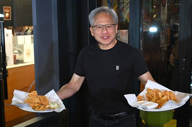 젠슨 황 엔비디아 최고경영자가 지난달 30일 서울 삼성동 한 치킨집에서 진행된 이재용 삼성전자 회장, 정의선 현대차그룹 회장과 치맥 회동 중 시민에게 치킨과 감자튀김을 나눠주고 있다. [공동취재]