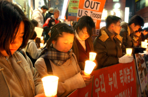 미군 장갑차에 희생된 여중생을 추모하는 행사가 경기도내 곳곳에서 이어지고 있는 가운데 수원 팔달문 중앙극장 앞에서 열린 촛불 추모행사에서 시민들이 촛불을 들고 희생된 여중생들의 명복을 빌고 있다. /경인일보DB